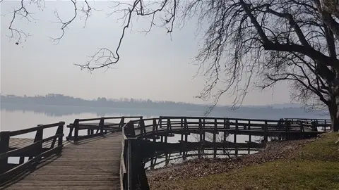 Seduta su una panchina accanto al lago, osservo il panorama.